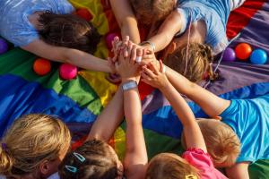 a group of children putting their hands up in the air at Domy Morskie Dog Friendly in Jantar