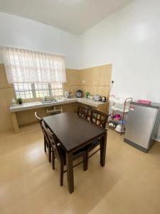 eine Küche mit Tisch und Stühlen und einem Kühlschrank in der Unterkunft Chloe's Homestay in Kuala Terengganu