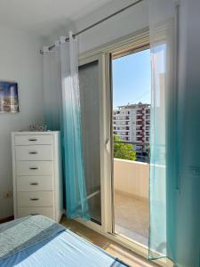 Adriatic City Center Vlora في فلوره: غرفة نوم مع باب زجاجي منزلق مع شرفة