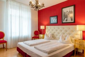 a bedroom with a large bed with red walls at Gasthaus Adler Ettenheim- mit self Check-In - Key Boxes in Ettenheim