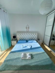 um quarto com uma cama grande e uma colcha azul em Adriatic City Center Vlora em Vlorë