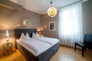 1 dormitorio con 1 cama, 1 silla y 1 lámpara de araña en Gasthaus Adler Ettenheim- mit self Check-In - Key Boxes, en Ettenheim
