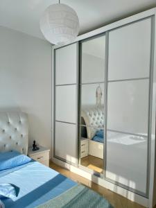 Adriatic City Center Vlora في فلوره: غرفة نوم بها سرير ومرآة كبيرة