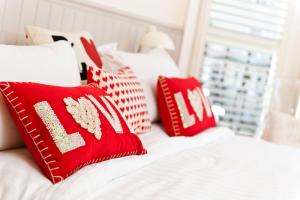 Una cama con almohadas rojas y blancas. en Strawberry Fields, en Brighton & Hove