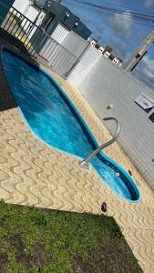 a large blue swimming pool with a hose in it at Residencial Havaí in João Pessoa