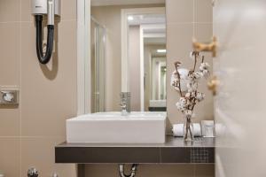 y baño con lavabo blanco y espejo. en Hotel Laurus - Liburnia, en Opatija