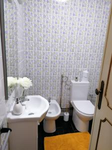 La salle de bains est pourvue d'un lavabo blanc et de toilettes. dans l'établissement CLE House, à Anadia