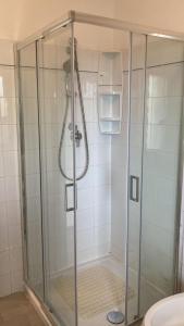 una doccia con porta in vetro in bagno di Appartamento al Mare con due Terrazze a Punta Marina