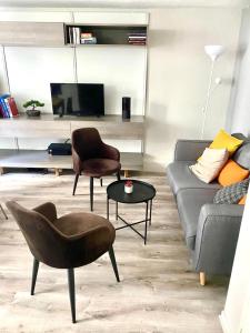 a living room with a couch and a chair and a table at Vieux-Lille : Appartement de charme in Lille