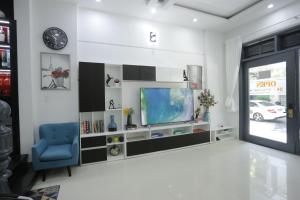 a living room with a tv and a blue chair at CHIENHOA HOMESTAY in Danang
