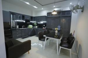 a kitchen with black cabinets and a table and chairs at CHIENHOA HOMESTAY in Danang