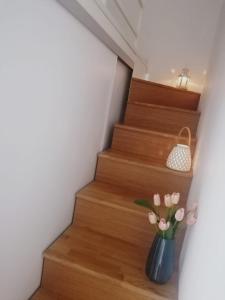 a vase with pink flowers sitting on the stairs at Historic Centre - Apartment Near Teatro Massimo in Palermo