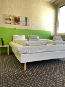 a large bed in a room with a green wall at Hotel Tabor Rooms in Vienna