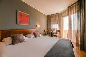 Un dormitorio con una gran cama blanca y una ventana en Hotel Laurus - Liburnia en Opatija