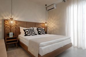 a bedroom with a large bed with black and white pillows at Polis of Naxos Stylish Suites in Naxos Chora
