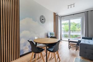 sala de estar con mesa, sillas y sofá en Apartamenty K2 Lubicka 7 en Toruń