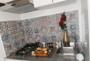 a kitchen counter with a sink and a stove with food on it at Historic Centre - Apartment Near Teatro Massimo in Palermo