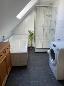 a bathroom with a tub and a washing machine at Casa Andrea 3-Zimmer Wohnung in Wallersdorf