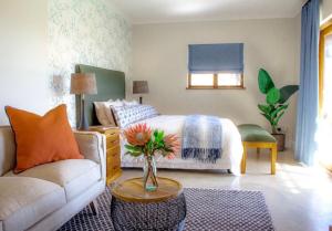 - une chambre avec un lit, un canapé et une table dans l'établissement Simbavati Fynbos on Sea, à Sedgefield