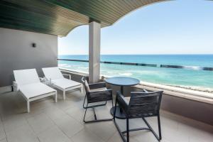 a balcony with chairs and a table and a view of the ocean at Hotel Faro, a Lopesan Collection Hotel - Adults Only in Maspalomas