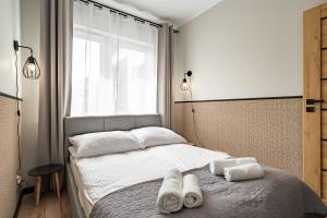 a bedroom with a bed with towels on it at Apartamenty K2 Lubicka 7 in Toruń
