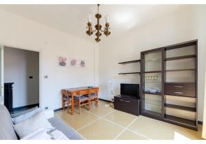 ein Wohnzimmer mit einem Sofa, einem Tisch und einem Kronleuchter in der Unterkunft JOIVY Lovely Flat with Balcony in Rapallo