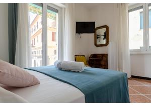 ein Schlafzimmer mit einem Bett mit einer blauen Decke und einem Fenster in der Unterkunft JOIVY Lovely Flat with Balcony in Rapallo