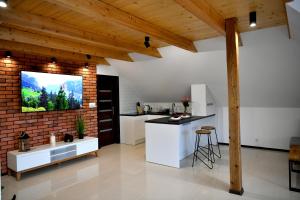 a kitchen with white cabinets and a brick wall at Apartament u Joli in Miejsce
