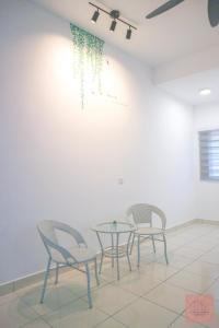 2 sillas y una mesa en una habitación en Homely, Self Check-In, Wi-Fi, Guarded Community, en Seremban