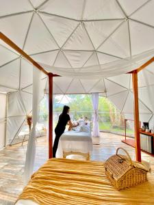 a woman in a tent set up a table at Orange Glamping in Quimbaya