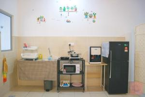 cocina con nevera y mesa con microondas en Homely, Self Check-In, Wi-Fi, Guarded Community, en Seremban
