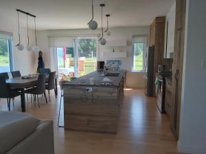 a kitchen and living room with a table and a kitchen and a dining room at Gîte du 149 route de la Mer in Sainte-Flavie