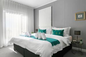 a bedroom with a large bed with blue and white at Century City Luxury Two Bedroom Apartment in Cape Town