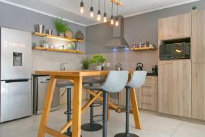 a kitchen with a wooden table and two bar stools at Century City Luxury Two Bedroom Apartment in Cape Town