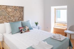 a bedroom with a large bed with a stone wall at Beautiful House in Miranda do Corvo