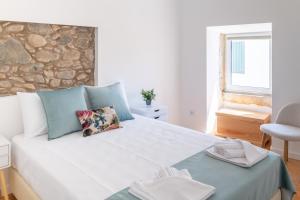 una camera da letto con un letto grande con un muro di pietra di Beautiful House a Miranda do Corvo