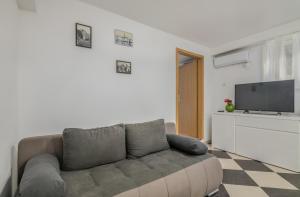 a living room with a couch and a flat screen tv at Apartments Dorotea in Krk