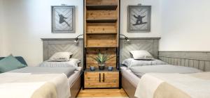 two twin beds in a room with a shelf at Apartman Stella in Mýto pod Ďumbierom +21 photos