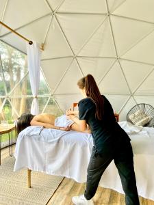 a woman standing in front of a bed in a tent at Orange Glamping in Quimbaya