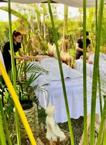 two people laying on a bed in a garden at Orange Glamping in Quimbaya