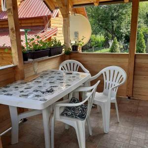 - une table blanche et 2 chaises sur la terrasse dans l'établissement Vikendica Mijajlović 2, à Kuršumlija