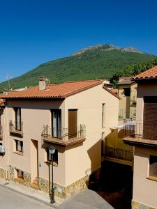 a group of buildings with a mountain in the background at El Escondite de Gredos in Lanzahita