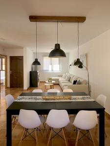 uma sala de estar com uma mesa e cadeiras brancas em El Escondite de Gredos em Lanzahita