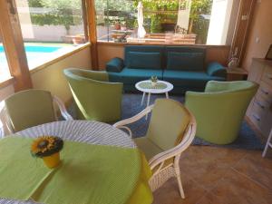 a room with a table and chairs and a couch at Villa Malina in Donja Raštelica
