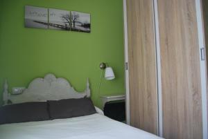 1 dormitorio con cama y pared verde en Apartamento A Cascada en Cee