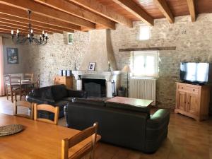a living room with a couch and a fireplace at La Ferme bio de la Salvanié in Bellegarde