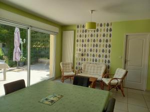 uma sala de jantar com mesa e cadeiras em Le jardin d'Anatole em Bourges