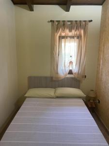 Ce lit se trouve dans un dortoir doté d'une fenêtre. dans l'établissement Casetta Albizia, à San Vito dei Normanni