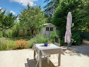 stół i parasol w ogrodzie w obiekcie Le jardin d'Anatole w mieście Bourges