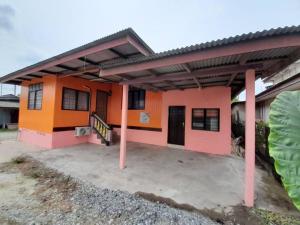 a small house with an orange and pink at AMZ WOODHOMESTAY AT GONG KIAT, KUALA TERENGGANU in Kuala Terengganu
